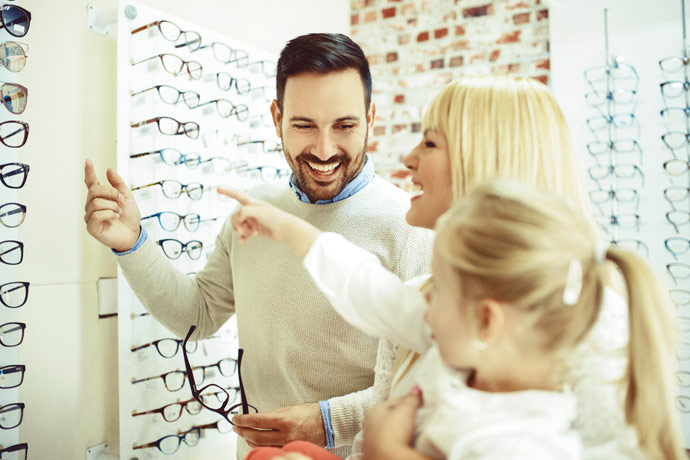 O familie care se uita la ochelari si zambeste intr-un magazin de optica medicala precum Oftapro Optics