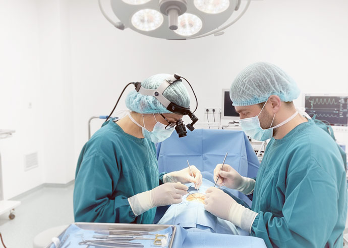 Imagine cu doi medici oftalmologi de la Clinica Oftapro care fac o operatie chirurgicala oftalmologica de strabism unui pacient